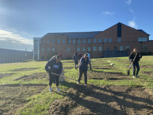 A group of faculty and students planting and tilling in seeds on Indigenous Peoples Day