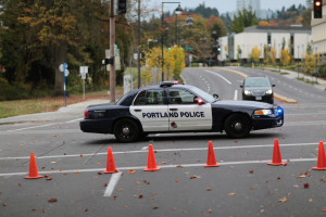 A Portland Police Crown Victoria vehicle blocking an intersection behind several orange traffic cones