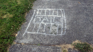 A sidewalk chalk drawing of the Self Help Radio logo in jail.