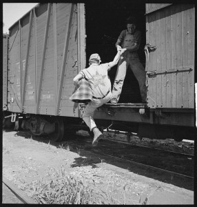 Hobos hopping a train - one of them has the Self Help Radio logo on their shirt.