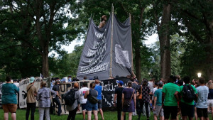 Activists surrounded by cops obscure the Silent Sam statue before it is torn down