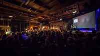 An audience who is intently watching speakers on a stage Think and Drink Bend, Oregon