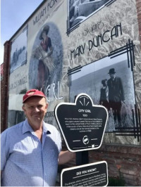 Rob McIntyre outside the Gem Theatre's "City Girl" mural